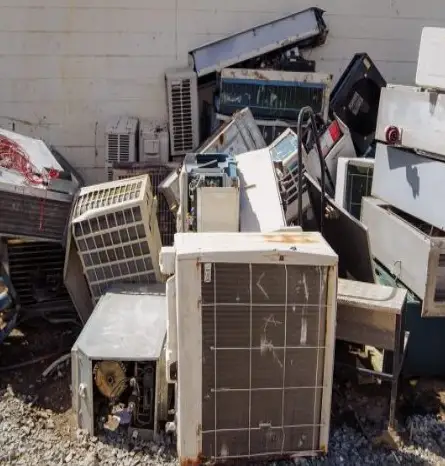 Discarded air conditioners against a wall